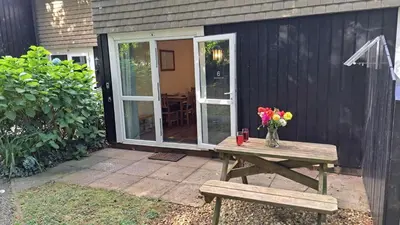 a wooden picnic table with a vase of flowers on it at 06 Strawberry Hill, Tolroy Manor in Hayle