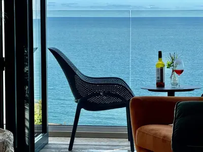 a chair and a table with a bottle of wine at Bayvista in St Ives