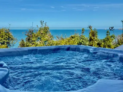 a hot tub with the ocean in the background at Bayvista in St Ives