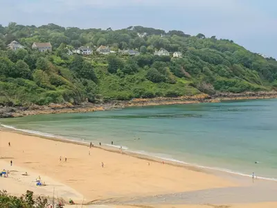 a group of people on a beach near the water at Bayvista in St Ives