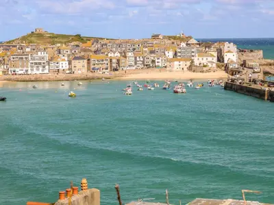 a group of boats in the water near a beach at Bayvista in St Ives