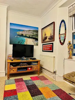 a living room with a flat screen tv on a table at Seaway Beach House Looe Beach in Looe