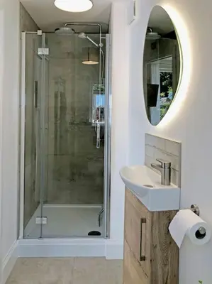 a bathroom with a shower and a sink and a mirror at The Cuckoo's Nest - A Romantic & Peaceful Hideaway in Kenwyn