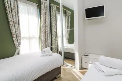 a bedroom with a bed and a window and a television at Bay View in Redruth