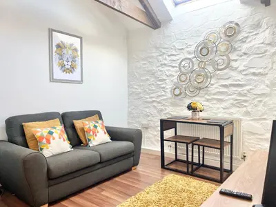 a living room with a couch and a table at Cosy Cornish Hideaway Hayle in Hayle