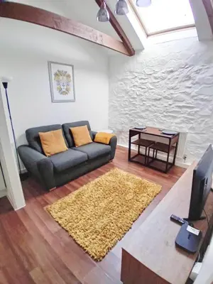 a living room with a couch and a table at Cosy Cornish Hideaway Hayle in Hayle