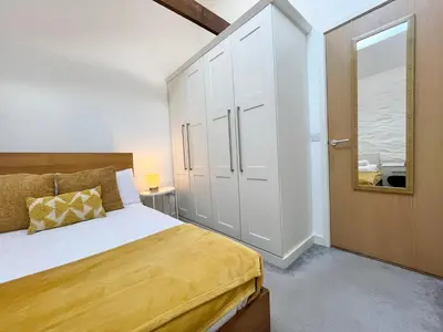 a bedroom with a large bed and a closet at Cosy Cornish Hideaway Hayle in Hayle