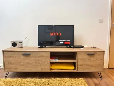 a tv sitting on top of a wooden entertainment center at Cosy Cornish Hideaway Hayle in Hayle