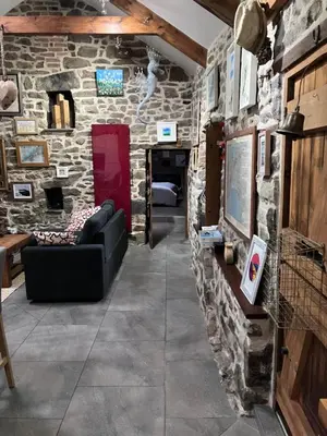 a living room with a stone wall at Anvil The Old Smithey in Saint Erth