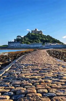 a cobble stone road leading to a castle on a hill at Anvil The Old Smithey in Saint Erth