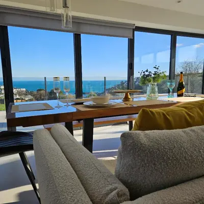 a dining room with a table with wine glasses at Luxury Seaview, Modern, 6 beds in Mevagissey