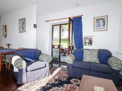 a living room with two couches and a table at The Hayloft in Liskeard