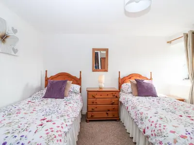 a bedroom with two beds and a dresser at The Hayloft in Liskeard
