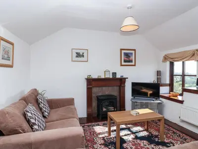 a living room with a couch and a fireplace at The Dairy in Liskeard