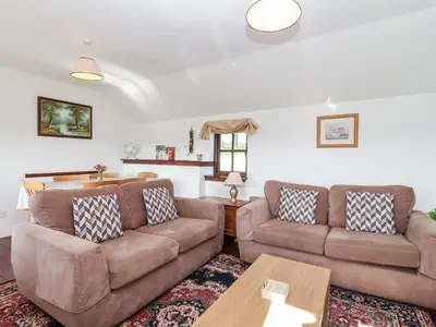 a living room with two couches and a table at The Dairy in Liskeard