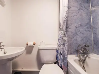 a bathroom with a sink and a toilet and a bath tub at The Byre in Liskeard