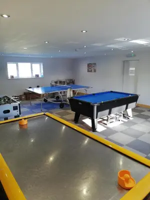 a ping pong room with two ping pong tables at The BarnsPigallie in Redruth