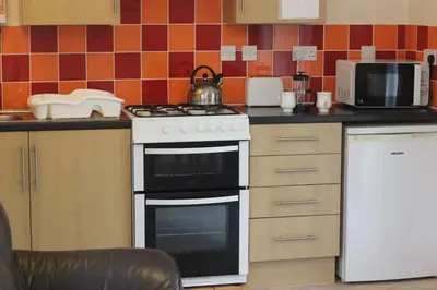 a kitchen with a stove and a microwave at The BarnsPigallie in Redruth