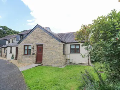 a brick house with a red door and a yard at Chy Lowena in Falmouth