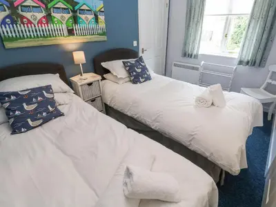 two twin beds in a room with a window at Chy Lowena in Falmouth