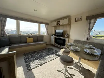 a living room with a table and a couch at Perranporth Coastal Retreat- Sleeps8 in Perranporth