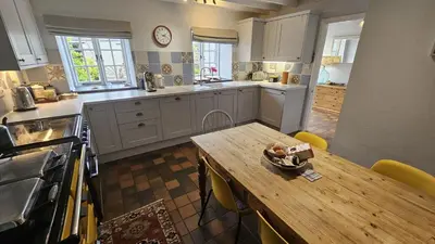 a kitchen with a wooden table and a wooden counter top at Glebe Barn in Ruan Lanihorne