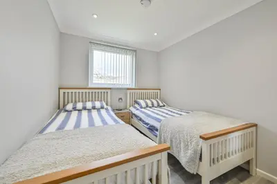 two beds in a room with white walls and a window at 118 Sandyfeet Retreat in Saint Martin