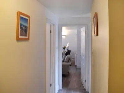 a hallway with a living room with a couch at Harbour Reach in Mevagissey