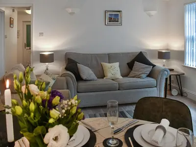 a living room with a couch and a table at Harbour Reach in Mevagissey