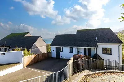 a white house with a fence and the ocean at 4 Bed in Carbis Bay oc-m30075 in Carbis Bay