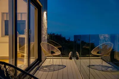 two chairs sitting on a balcony with a window at 4 Bed in Carbis Bay oc-m30075 in Carbis Bay