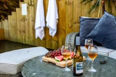 a table with two glasses of wine and a plate of fruit at 4 Bed in Carbis Bay oc-m30075 in Carbis Bay