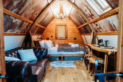 a bedroom with a couch and a bed in a room at Wild Wren - A Nordic Getaway in Callington