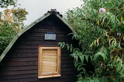 a small house with a sign on the top of it at Wild Wren - A Nordic Getaway in Callington