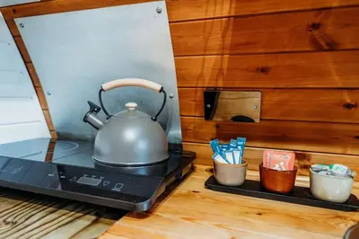 a tea kettle sitting on top of a stove at Wild Wren - A Nordic Getaway in Callington