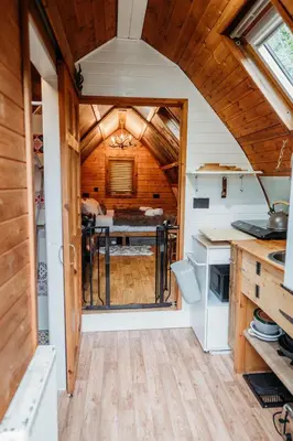 a kitchen with an open door in a tiny house at Wild Wren - A Nordic Getaway in Callington