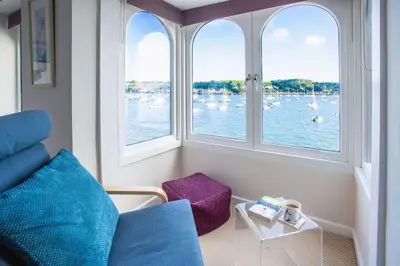 a room with windows with boats in the water at Janes Court, Packet Quays in Falmouth