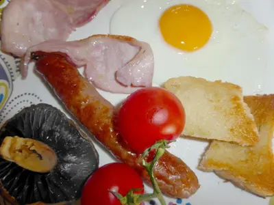 a plate of food with eggs bacon tomatoes and toast at Tregondale Manor Farm in Liskeard