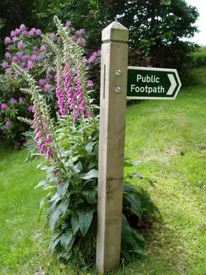a wooden sign in front of a flower garden at Tregondale Manor Farm in Liskeard