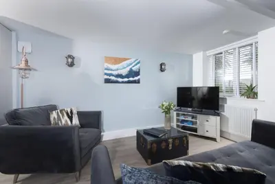 a living room with two couches and a tv at Offshore, Carbis Bay, St Ives in Carbis Bay