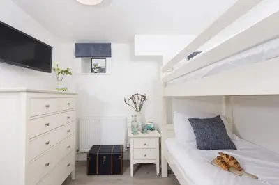 a bedroom with a bed and a dresser with a tv at Offshore, Carbis Bay, St Ives in Carbis Bay