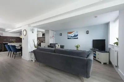 a living room with a couch and a tv at Offshore, Carbis Bay, St Ives in Carbis Bay