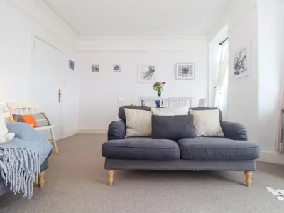 a living room with a blue couch and a chair at Mor Kernow in St Ives