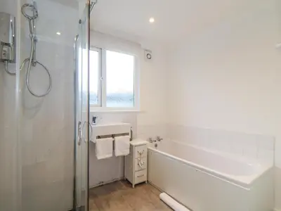 a bathroom with a tub and a sink and a shower at Mor Kernow in St Ives