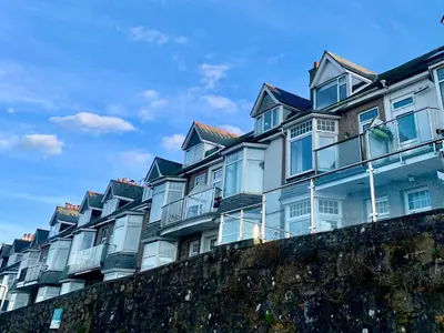 a row of houses on top of a wall at Mor Kernow in St Ives