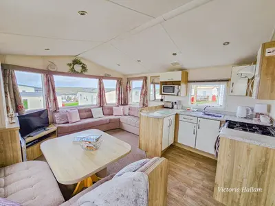a kitchen and a living room with a caravan at Summer Breeze in Perranzabuloe