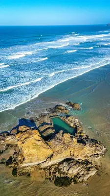 an aerial view of a rocky beach with the ocean at Summer Breeze in Perranzabuloe