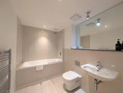 a bathroom with a sink and a toilet and a tub at Modern Apartment By The Beach in Newquay