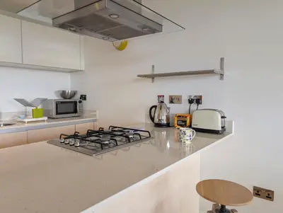 a kitchen with a stove and a microwave at Modern Apartment By The Beach in Newquay