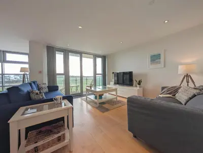 a living room with a couch and a tv at Modern Apartment By The Beach in Newquay